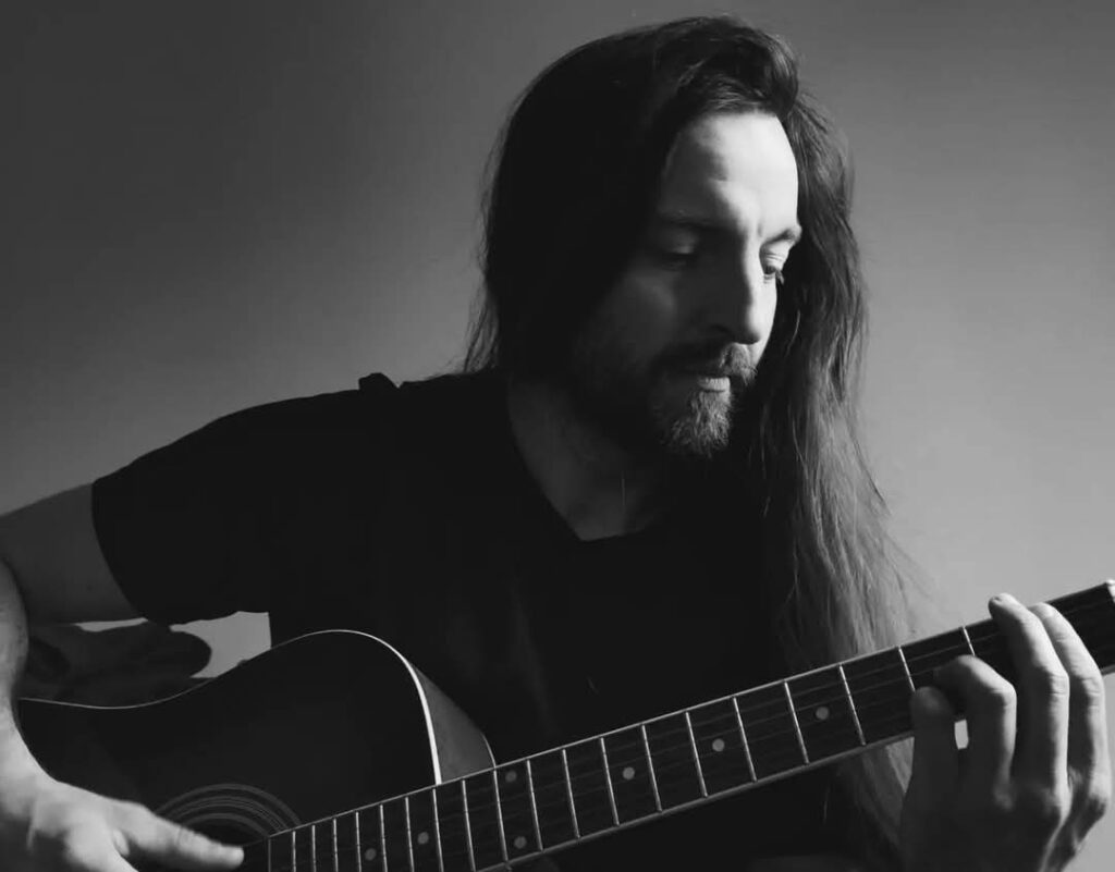 Vladan with guitar. Black and white photo.